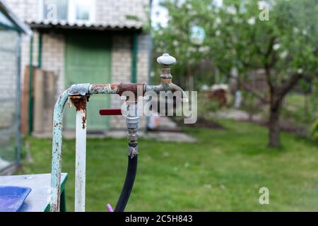 Alter, rostiger Wasserhahn auf dem Land Stockfoto