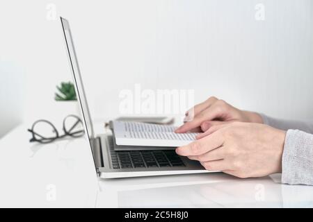 Frau sucht Informationen im Buch, Büro Arbeit Konzept auf weißem Wandhintergrund Stockfoto