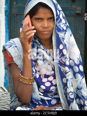 TIKAMGARH, MADHYA PRADESH, INDIEN - 15. NOVEMBER 2019: Portrait von nicht identifizierten indischen Frauen, die in ihrem Dorf mobil sprechen. Stockfoto