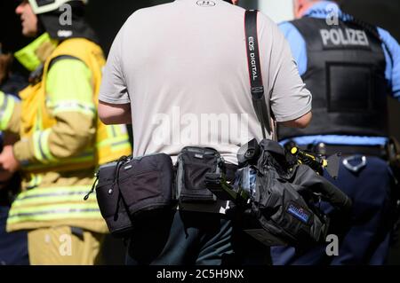 Dresden, Deutschland. Juni 2020. Ein sogenannter Blaulicht-Reporter steht bei einer Brandbekämpfung hinter einem Feuerwehrmann und einem Polizisten. Quelle: Robert Michael/dpa-Zentralbild/dpa/Alamy Live News Stockfoto