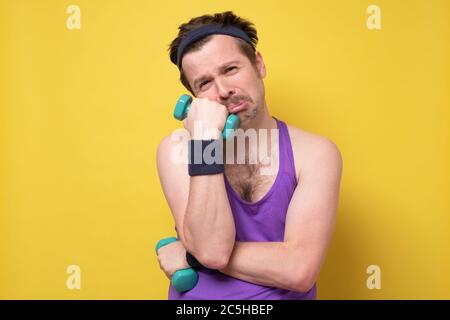Trauriger Mann mit einer Hantel, der nach dem Training müde war. Stockfoto