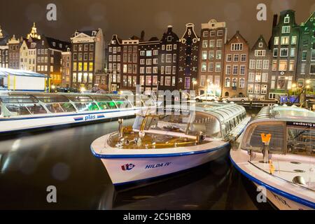 AMSTERDAM, NIEDERLANDE - JULI 08: Amsterdamer Kanal mit traditionellen Häusern und Ausflugsbooten. Amsterdam vom Wasser aus zu sehen ist bei Touristen sehr beliebt Stockfoto