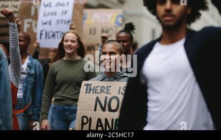 Gruppe von Aktivisten marschieren und protestieren in der Stadt. Frau protestiert mit einer Gruppe von Menschen auf der Straße. Stockfoto