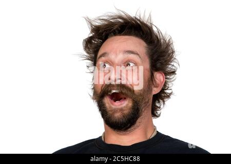 Der junge Mann mit Vollbart und Schnurrbart und wilder Frisur schreit vor Freude. Studio Porträt über weiß. Platz für Ihren Text. Stockfoto