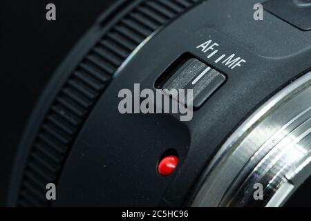 Makro Nahaufnahme Foto von Objektiv zu dslr-Kamera auf dunklen Hintergrund Ansicht von roten Punkt und silbernen Verlängerungsring und Autofokus-Taste. Stockfoto