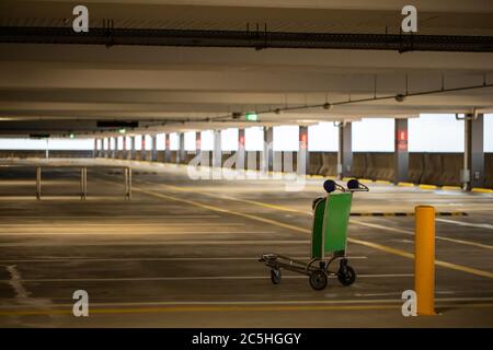 Ein leerer Parkplatz am Flughafen während der Corona COVID-19 Pandemie, Trolley-Wagen steht verlassen Stockfoto