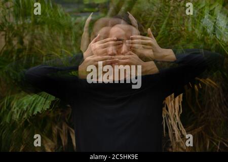 Junger asiatischer Mann mit langen Haaren im Park mit mehrfacher Belichtung Stockfoto