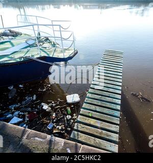 Plastikflaschen, Pakete, Müll im Fluss in der Nähe Yacht. Illegale Müllhalde, Wasserverschmutzung. Stockfoto