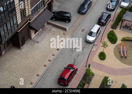 UKRAINE, KIEW - 20. Mai 2020: Der Mann in einem weißen Schutzanzug und einer Maske geht auf einer Straße, um Innenflächen in Gebäuden zu sanieren Stockfoto