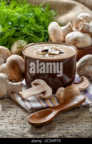 Cremesuppe mit Champignons Champignon in einer Schüssel, Vintage-Stil Komposition auf einem rustikalen Holztisch. Stockfoto