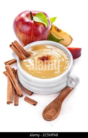 Apfelmus oder Sauce in einer weißen Keramikschale mit Zimt und Apfelscheiben. Isoliert auf Weiß. Das Konzept der gesunden Ernährung und Lebensstil. Stockfoto