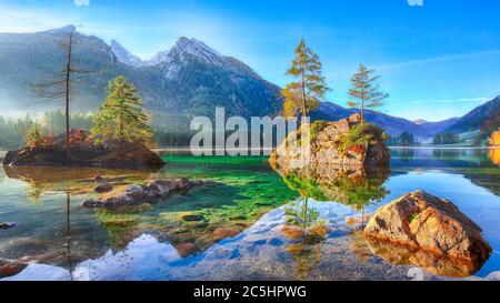 Fantastischer Herbstaufgang am Hintersee. Schöne Szene von Bäumen auf einer Felseninsel. Lage: Resort Ramsau, Nationalpark Berchtesgadener Land, nach oben Stockfoto