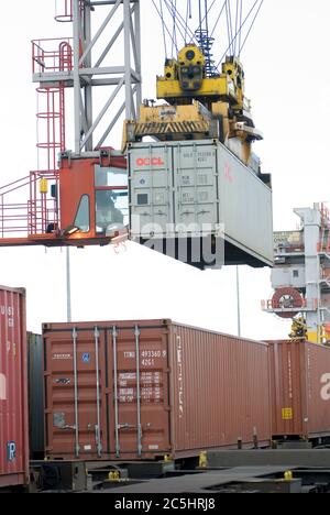 Der Kran wird auf der Schiene montiert, um Transportbehälter aus einem Zug am Manchester Euroterminal, Trafford Park, Manchester, England zu laden und zu entladen. Stockfoto