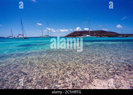 Farbenfrohe Sicht auf die Tobago Cays mit Yachten im Anchor im ruhigen Türkismeer bei der Insel Petit Rameau. Stockfoto