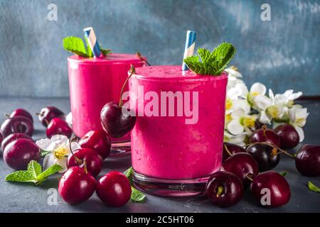 Süßer Kirsch-Smoothie-Drink in Gläsern mit Minzblättern und frischen Beeren Stockfoto