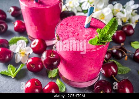 Süßer Kirsch-Smoothie-Drink in Gläsern mit Minzblättern und frischen Beeren Stockfoto