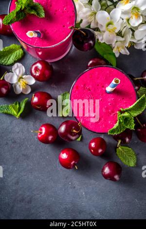 Süßer Kirsch-Smoothie-Drink in Gläsern mit Minzblättern und frischen Beeren Stockfoto