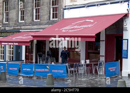 Grassmarket Edinburgh, Schottland, Großbritannien. Juli 2020. Anzeichen der Tätigkeit des Personals in einigen der Pubs und Restaurants im Grassmarket. An dem Tag, an dem die Reisebeschränkung für fünf Meilen in Schottland aufgehoben wird, da die Einschränkungen des Covid-19-Virus leichter werden, beginnen Pubs und Restaurants in der Gegend sich auf die Rückkehr zur neuen Normalität vorzubereiten. Die Angestellten waren sauber und haben die Sitzgelegenheiten organisiert. Ab dem 15. Juli können Pubs und Restaurants in ganz Schottland ihre Türen wieder für die Öffentlichkeit öffnen, nachdem sie wegen der Sperre geschlossen wurden. Stockfoto