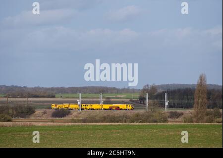 Network Rail Gleisstoppmaschine, die auf einem Bahnabschnitt in der englischen Landschaft arbeitet. Stockfoto