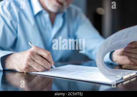 Geschäftsmann unterzeichnet einen Vertrag im Amt. Stockfoto