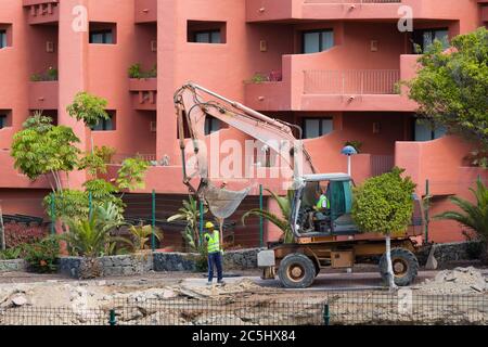 TENERIFFA, KANARISCHE INSELN - 17. MAI 2018. Bulldozer Graben, Bauarbeiten machen Lärm und ruinieren Urlaub neben Hotelzimmer, Costa Adeje Stockfoto