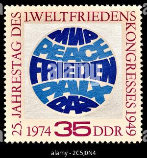 Briefmarke Ostdeutschland (1974) : 25. Jahrestag des 1. Weltfriedenkongresses, 1949. 'Peace' auf Russisch, Englisch, Deutsch, Französisch und Spanisch Stockfoto