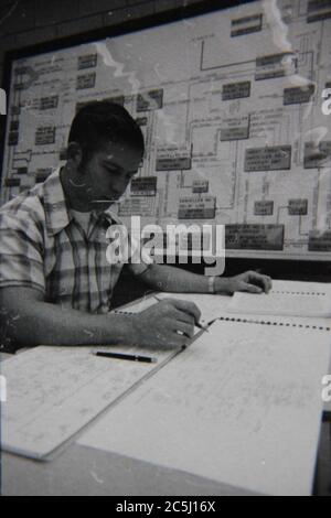 Feine 70er Jahre Vintage schwarz-weiß Lifestyle-Fotografie eines Büroangestellten Hand schreiben und gehen durch Tonnen von Papierkram als tägliche Arbeit. Stockfoto