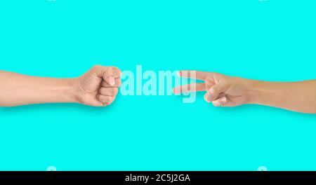 Zwei Hände spielen Rock-Papier-Schere auf blauem Hintergrund Stockfoto
