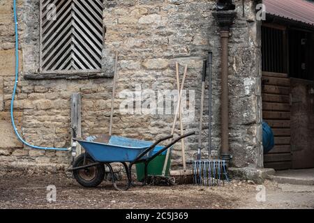 Detailansicht außerhalb eines Stalls und Lackierung Block zeigt verschiedene Werkzeuge verwendet, um die Pferdestall zu reinigen. Stockfoto