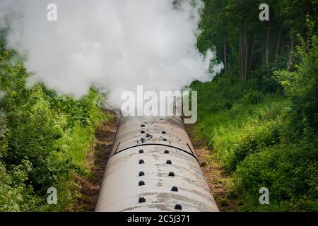 Eisenbahnbrücke Ansicht einer berühmten, britischen Dampflokomotive gesehen ziehen eine Reihe von Pkw entlang einer einzigen Spur. Stockfoto