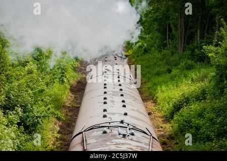 Eisenbahnbrücke Ansicht einer berühmten, britischen Dampflokomotive gesehen ziehen eine Reihe von Pkw entlang einer einzigen Spur. Stockfoto