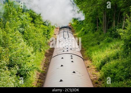 Eisenbahnbrücke Ansicht einer berühmten, britischen Dampflokomotive gesehen ziehen eine Reihe von Pkw entlang einer einzigen Spur. Stockfoto