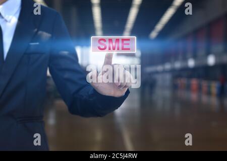 Businessman hand pressing button SME icon. Concept of small and medium-sized enterprises business. Stockfoto