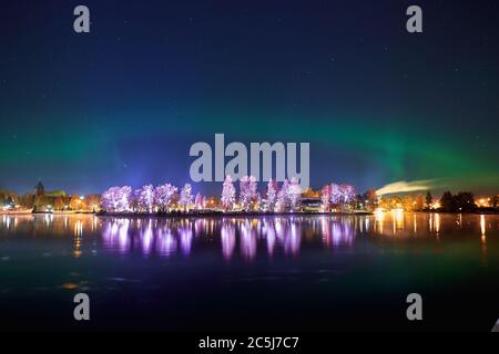Blick auf die Insel Ilosaari bei Nacht auf dem Hintergrund von Sternenhimmel und aurora, Joensuu, Finnland Stockfoto