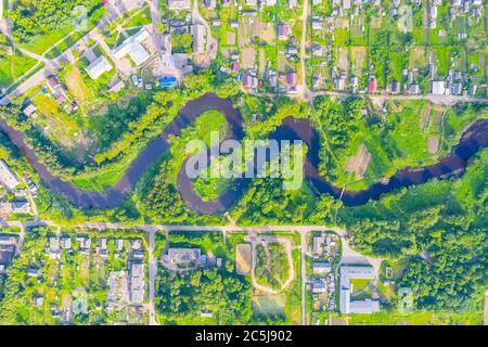 Luftbild Landschaft von gewundenen kleinen Fluss zwischen der kleinen Stadt, Bach im grünen Feld, Draufsicht Wiese Stockfoto