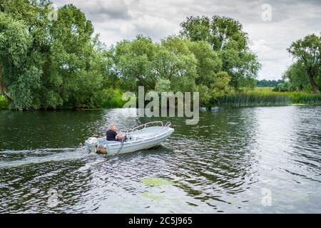 Kleines Motorboot auf einer Binnenschifffahrt mit einer Person an Bord. Stockfoto
