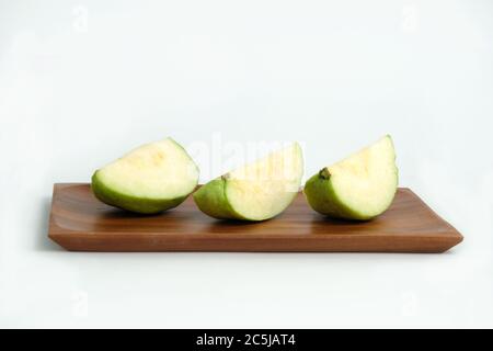 Geschnittenes grünes Kristall Guava rohe Frucht auf einem Holzplatte isoliert auf einem weißen Hintergrund Stockfoto