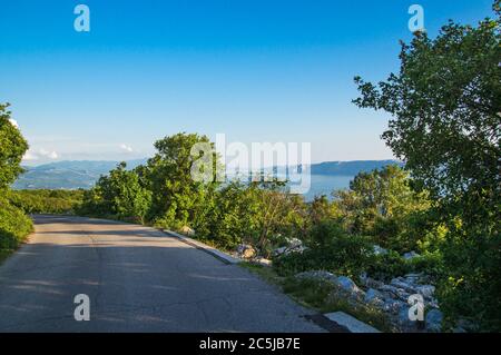 Blick entlang der kroatischen Küste, die von den Bergen auf einer asphaltierten Straße. Stockfoto