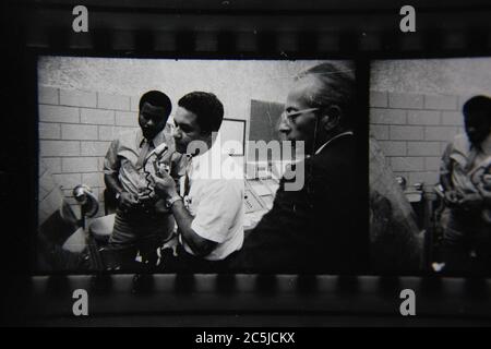 Feine 70er Jahre Vintage Kontakt Print schwarz-weiß Fotografie einer Gruppe von Mitarbeitern diskutieren Strategie zur Lösung eines Problems. Stockfoto