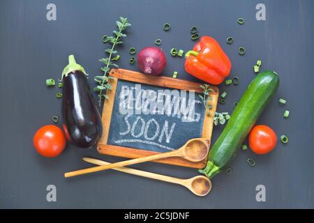 Tafel des Restaurants, die die Wiedereröffnung nach der Corona-Sperre, Kochen, Betriebsstilllegung ankündigt. Küchenutensilien und Zutaten für Lebensmittel. Stockfoto