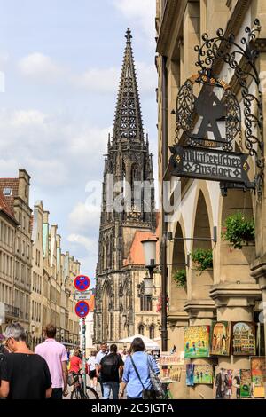 Menschen und Einkäufer im Prinzipalmarkt, mit dem gotischen Turm der St. Lamberts Kirche dahinter, Münster in Westfalen, Nordrhein-Westfalen, Deutschland Stockfoto