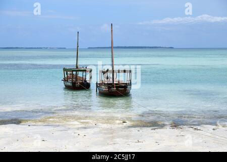 Sansibar, Tansania - 4. Oktober 2019: Blaues transparentes Wasser und zwei Fischerboote auf der Kendwa-Küste, Sansibar, Tansania, Afrika Stockfoto