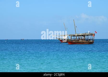 Kendwa, Sansibar - 6. Oktober 2019: Blaues transparentes Wasser und zwei traditionelle Fischerboote dhow im Indischen Ozean, Sansibar, Tansania, Afrika Stockfoto