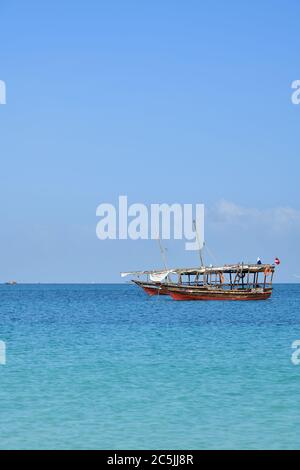 Kendwa, Sansibar - 6. Oktober 2019: Blaues transparentes Wasser und zwei traditionelle Fischerboote dhow im Indischen Ozean, Sansibar, Tansania, Afrika Stockfoto