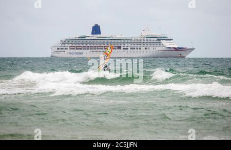 Bournemouth, Dorset, Großbritannien, 3. Juli 2020. Ein einsamer Windsurfer passiert ein Kreuzfahrtschiff am Bournemouth Beach, da die COVID-19-Sperrregeln in Großbritannien gelockert sind. Credit John Beasley/Alamy Live News Stockfoto