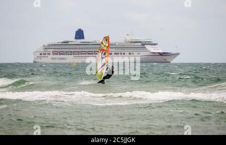 Bournemouth, Dorset, Großbritannien, 3. Juli 2020. Ein einsamer Windsurfer passiert ein Kreuzfahrtschiff am Bournemouth Beach, da die COVID-19-Sperrregeln in Großbritannien gelockert sind. Credit John Beasley/Alamy Live News Stockfoto