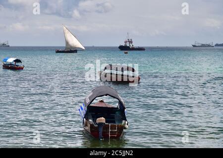 Sansibar, Tansania - 7. Oktober 2019: Dhow-Segelboot und andere Schiffe im Hafen von Stone Town, Sansibar, Afrika Stockfoto