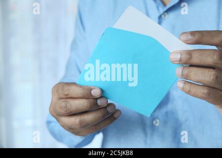 Nahaufnahme der Hand mit blauem Umschlag. Stockfoto