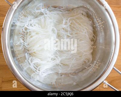 Das Wasser aus der Fjunchoza ablassen. Kochen klare Nudeln. Vermicelli in einem Sieb. Stockfoto