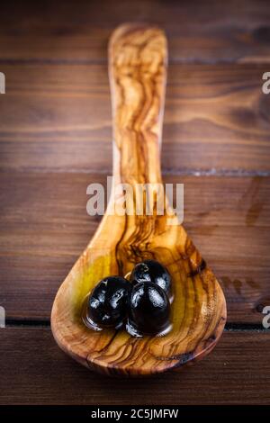 Schwarze Oliven auf rustikalem Tisch aus Apulien, Italien